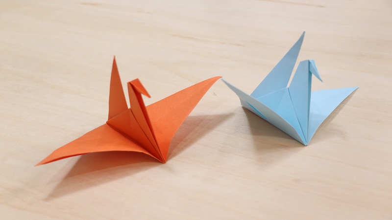 然后将一个尖角向下折出千纸鹤的头部,最后将翅膀展开,可爱的千纸鹤就